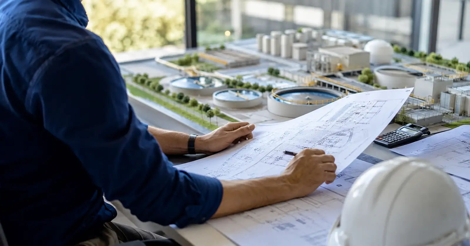 Engenheiro analisando planta técnica de projeto ambiental